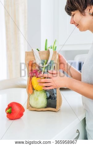 Woman Holding Reusable Eco Sackcloth Fabric Bag Packaging With Fresh Organic Vegetables On White Kit
