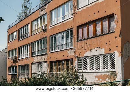 Riddled wall after the Balkans war in Sarajevo, Bosnia Herzegovina. Bullet holes on the yellow wall