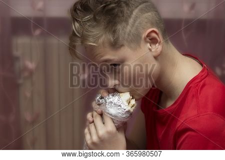 Blond-haired Boy Eats Shawarma At Home. Eating Fast Food At Home In The Room.