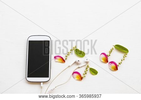 Mobile Phone ,earphone With Petal Coloful Flowrers Frangipani Arrangement Music Score Flat Lay Style