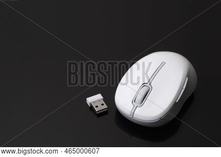 White Computer Mouse With Receiver Or Dongle On Black