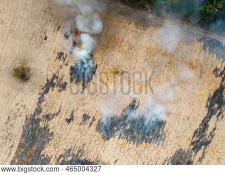Aerial View Of Agriculture Farm With Smoke From Crop Fire Burning Releases Carbon Dioxide. Greenhous