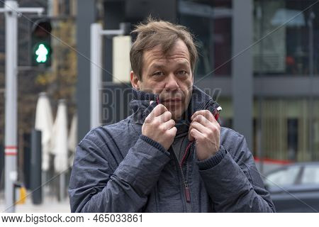 Street Portrait Of A Man 45-50 Years Old Against A Blurred Background Of Modern Buildings, Jacket Co