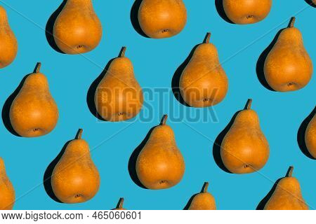Colorful Pear Pattern. Yellow And Orange Bera Pears On A Blue Background. Ripe Juicy Fruits Top View