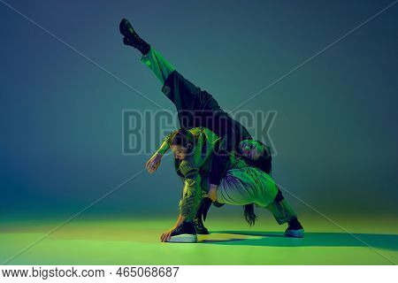 Modern Dance Concept. Energetic Couple Of Two Young Woman Dancing Contemporary Dance On Gradient Blu
