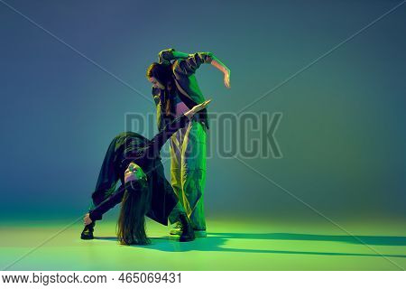 Young Stylish Flexible Girls In Modern Attires Dancing Contemp Style Dance Isolated Over Gradient Bl