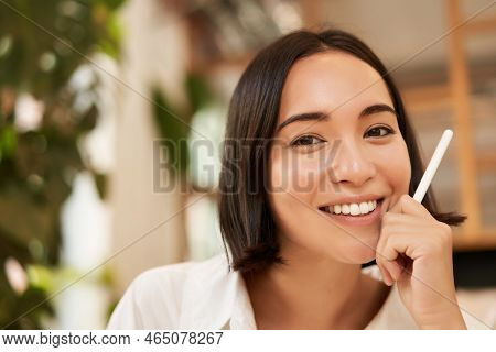 Close Up Portrait Of Stylish Young Brunette Woman, Sitting With Graphic Pen And Smiling, Relaxing In