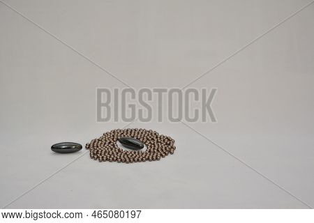 Two Units Magnet Or Magnet With Craft Balls Forming A Silver Circle. Selective Focus. White Backgrou
