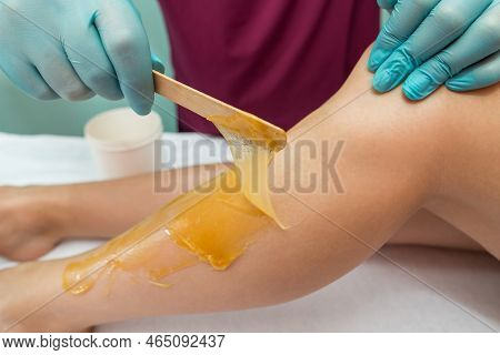 Woman Undergoing Leg Hair Removal Procedure With Sugaring Paste In Salon. Skin Care, Remove Hair Wit