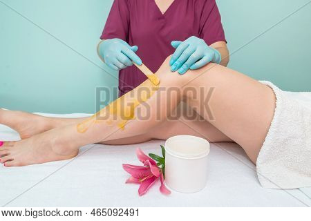Leg Sugaring. A Beautician Makes A Sugar Paste Depilation Of A Woman's Legs In A Beauty Salon. Femal