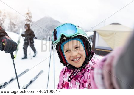 Active Adorable School Caucasian Kid Girl Portrait Enjoy Have Fun Making Selfie Photo Skiing In Helm