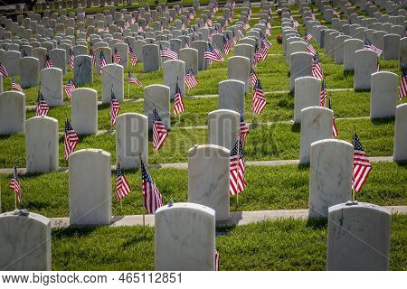 Military Grave Markers Decorated With American Flags For Memorial Day