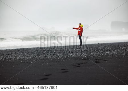 Man Watching The Waves Crash On Reynisfjara Beach