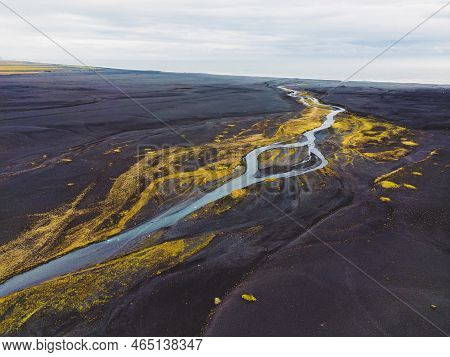 A River Running Trough The Black Sands Beach Of Selheimasandur