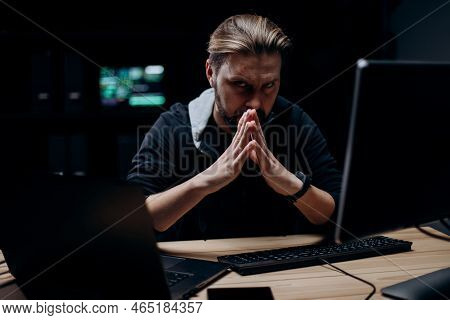 Portrait Of Redoubted Bearded Man Wearing Black Hoodie Using Modern Computers For Massive Attack Of 