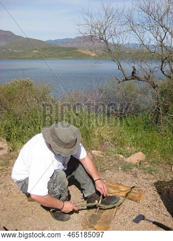 Man In Wild Starting Fire With Sticks And String By Hand