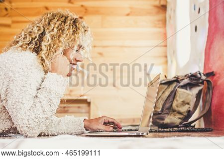 Cheerful Happy Beautiful Blonde Curly Caucasian Woman Working At Computer Laptop Lay Down Onthe Floo