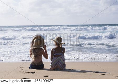 People At The Beach - Couple Of Young Beautiful Tourist Girls Sitting On The Sand Near The Shore Enj
