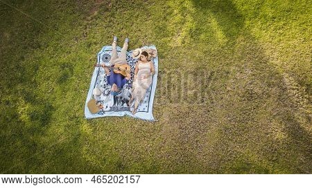 Couple Of Two Adults Lyied Down On The Grass Enjoying The Outdoor Leisure Activity Together - Man Pl