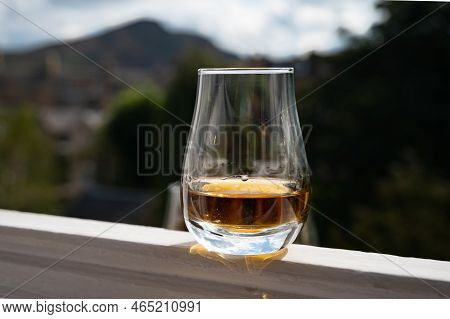 Glass Of Single Malt Scotch Whisky Served On Old White Window Sill In Scottisch House With View On O