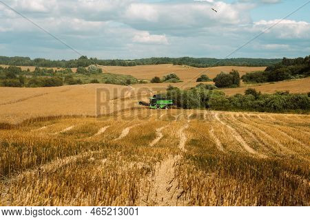 Russia, Kaliningrad - July 27, 2022: Rapeseed Harvest. Combine Harvester In The Field