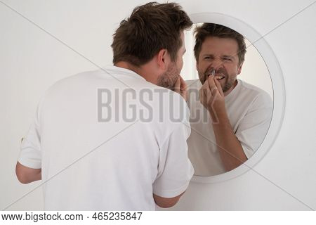 Suffering Bearded Man Plucking Out His Nose Hair.