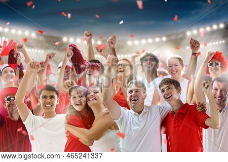 Football Supporter On Stadium In Red And White Shirt. Happy Fans On Soccer Pitch Watching Winning Te