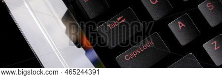 Fragment Of A Black Trendy Mechanical Computer Keyboard With A Red Font And A Glass Prism On A Black