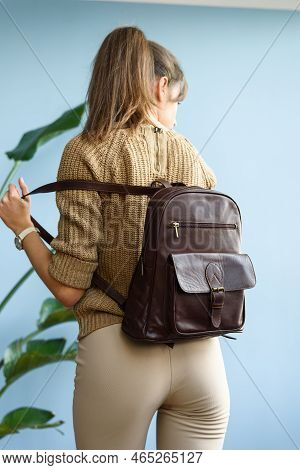 Beautiful Slender Girl In Beige Pants And Olive Sweater Posing With A Small Shiny Brown Leather Back