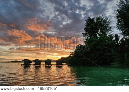 Beautiful Sunset Above Typical Water Bungalows On The Beach - Waigeo Island, Raja Ampat, West Papua,