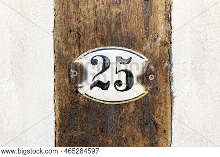 House Number Twenty-five - Old Rusty 25 Plaque Mounted On Timber Frame Building