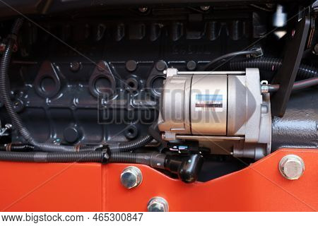 Silver Tractor Electric Starter. Closeup Of New Tractor Starter With Wiring Mounted Above Tractor Mo