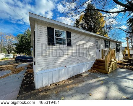 Side View Of Brand New Prefab Mobile Home With For Sale Yard Sign Post In Rochester, New York