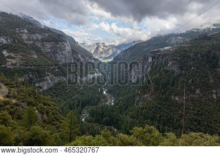 Valley In Yosemeti National Park With Conifers, Low Clouds, Cloudy Sky And Patches Of Fog, Californi