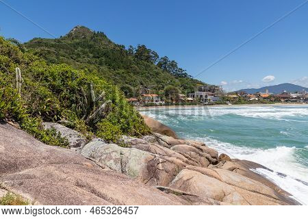 Beach Viewwith Rocks, Forest, Houses And Mountain