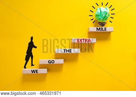 We Go The Extra Mile Symbol. Wooden Blocks With Words We Go The Extra Mile. Beautiful Yellow Backgro