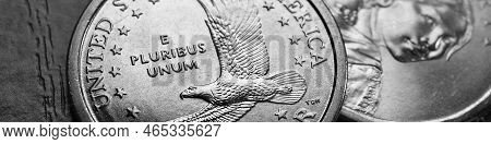 American Coins Close-up Lie On Dark Surface Of Table. Soaring Eagle Sacagawea Dollar Coin. Us Econom