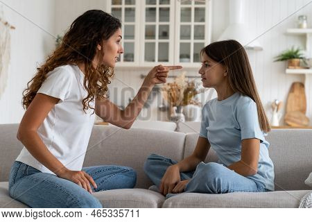 Nervous Caucasian Woman Looks With Anger At Guilty Daughter Who Does Not Want To Obey Parents Or Beh