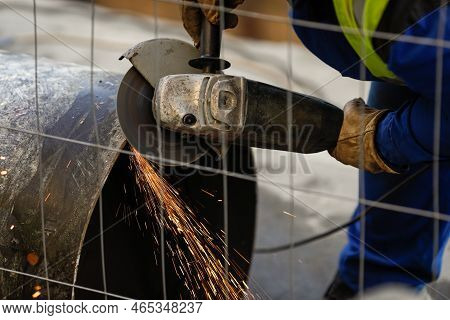 Shallow Depth Of Field (selective Focus) Details With A Worker Using An Angle Grinder On An Industri