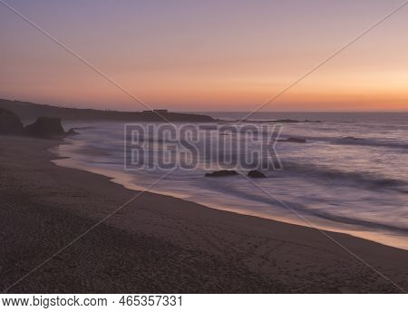 Mysterious Long Exposure View Of Sand Beach Praia Grande De Almograve With Blurred Ocean Waves In Pi