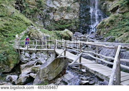 Unrecognizabe Woman On A Wooden Bridge In Sonogno, Switzerland