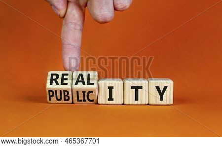 Reality Or Publicity Symbol. Businessman Turns Wooden Cubes And Changes The Word Publicity To Realit