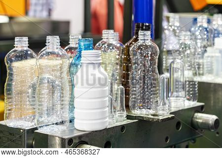 Various Sample Transparent Plastic Bottle And Other Color With  Preform Raw Material Place On Metal 