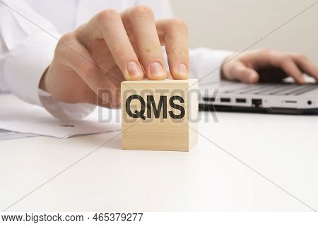 A Wooden Blocks With The Letters Qms Written On It On A White Background. Qms - Short For Quality Ma