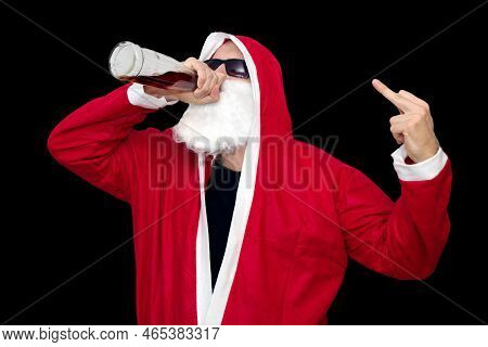 Bad Santa Claus Dress In Red Costume With Bottle Of Alcohol On Black Backround With Middle Finger Up