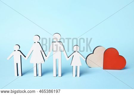 Figures Of Family Stainding Near Heart On Light Blue Background. Insurance Concept