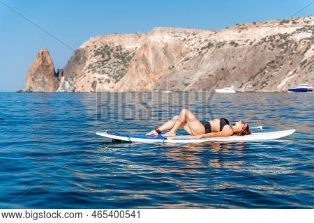 Sporty Girl On A Glanders Surfboard In The Sea On A Sunny Summer Day. Summer Activities By The Sea