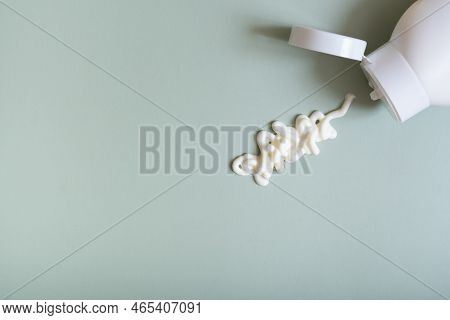 White Cosmetic Smear And Bottle On Pastel Green Background Top View