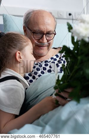 Little Girl Giving Flowers Bouquet Present, Hugging Grandfather Admitted To Hospital. Elderly Bedrid