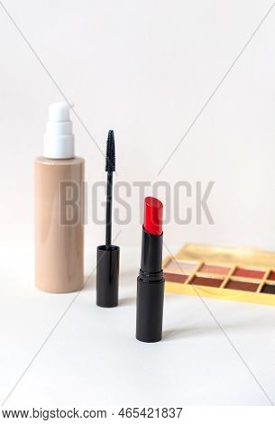 Beautiful Red Lipstick, Macara, Eye Shadows And Tone Cream On White Background. Professional Makeup 